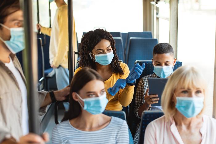People on a bus wearing masks